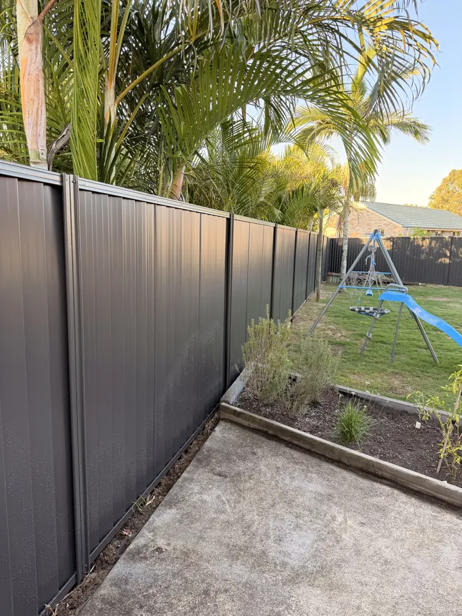 Charcoal Colorbond fence and matching gate around a backyard