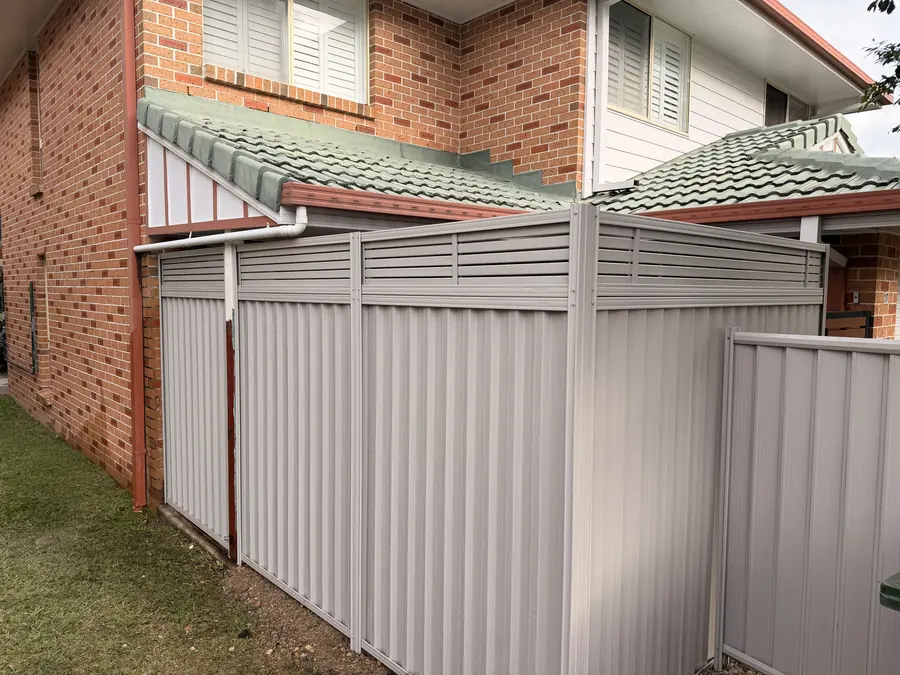 Colorbond fence with slat topper and matching gate between two homes