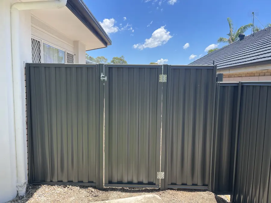 Charcoal Colorbond double swing gate at the side of a rendered home